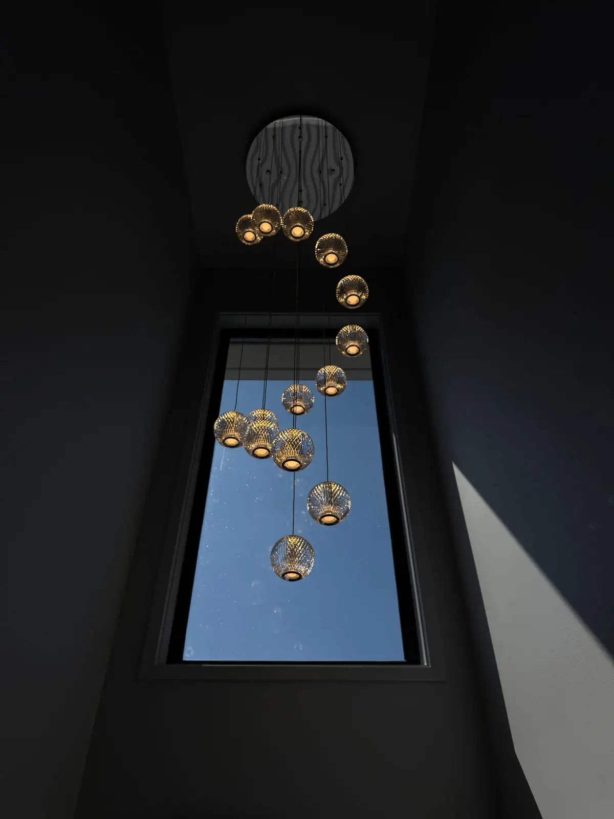 A cluster of glass feature pendants hung at staggered heights down a two-storey entry void