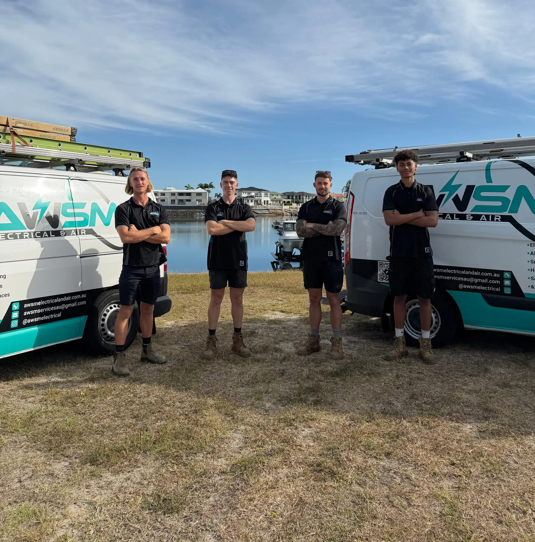 Dylan, Hayden and the AWSM crew standing in front of their two branded work vans