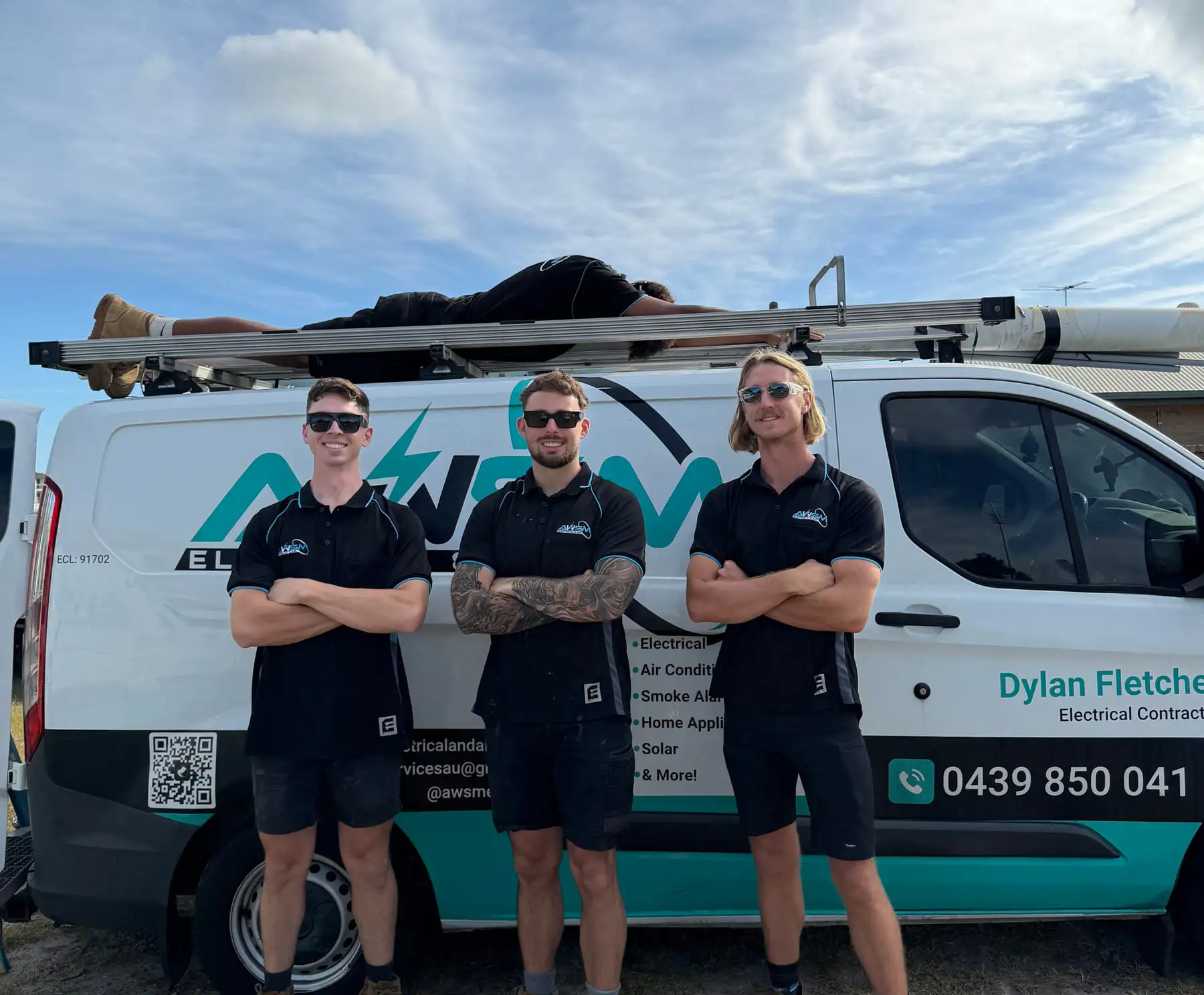 Three of the AWSM crew in front of a signwritten van showing the logo, licence number and Dylan's mobile